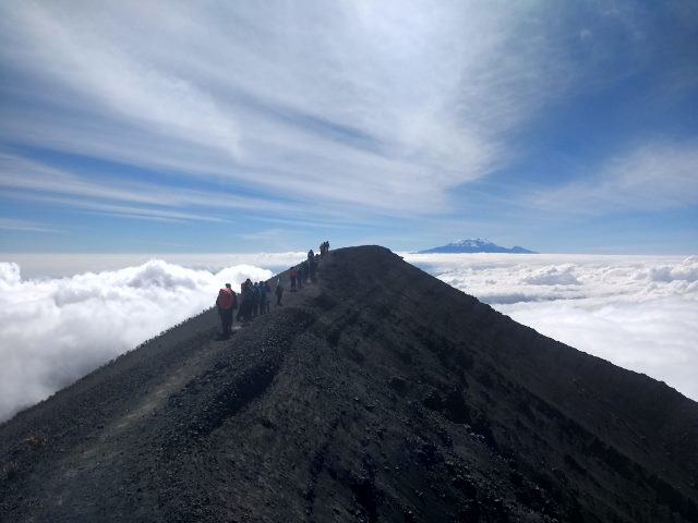 Mt Meru crater rim, below the main summit with Kilimanjaro in the background